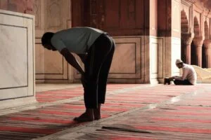 Two men praying inside the historic Jama Masjid in Delhi, India, highlighting spirituality and tradition.