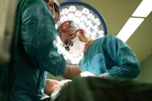 Two surgeons focused on performing an operation in a sterile operating room.